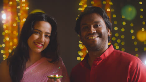 Porträt-Eines-Jungen-Paares,-Das-Das-Diwali-Fest-Feiert-Und-Eine-Diya-Öllampe-Anzündet